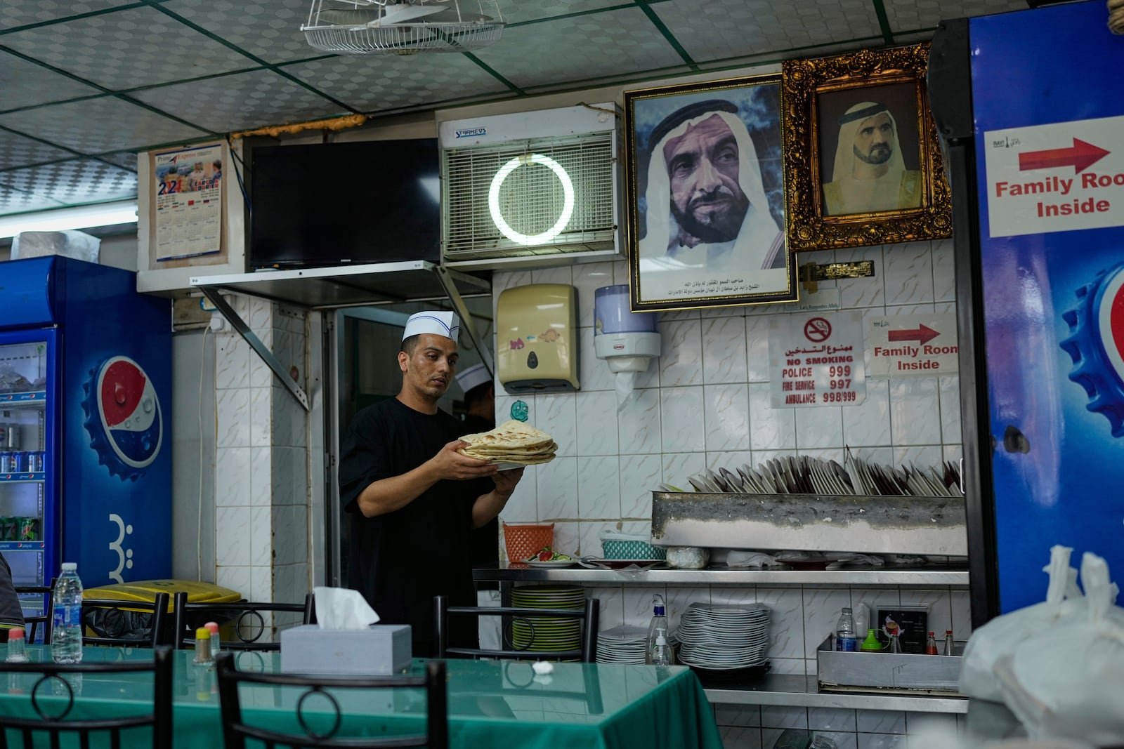 A waiter carries Roti or flat breads at Ravi restaurant in Satwa district of Dubai, United Arab Emirates, Monday, June 9, 2025. (AP Photo/Altaf Qadri)
