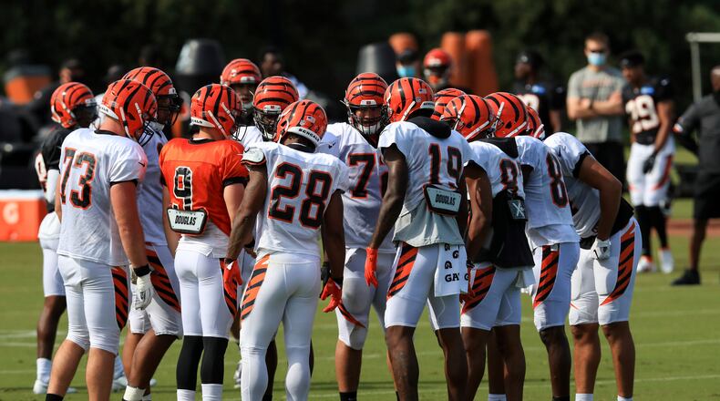 Cincinnati Bengals' Jonah Williams, left, Joe Burrow, middle left, Joe Mixon, middle, and Auden Tate, middle right, stand in team huddle during an NFL football camp practice in Cincinnati, Friday, Aug. 21, 2020. (AP Photo/Aaron Doster)
