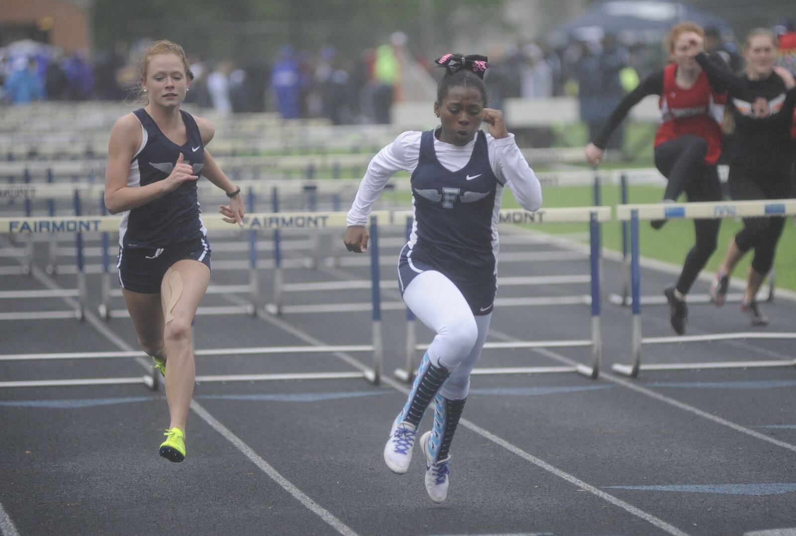 Fairmont’s Jazmyn Potts (middle) won the 100-meter hurdles (15.80) and teammate Emily Galentine (left) was second during the Firebird Track & Field Invitational at Fairmont on Friday, May 5, 2017. MARC PENDLETON / STAFF