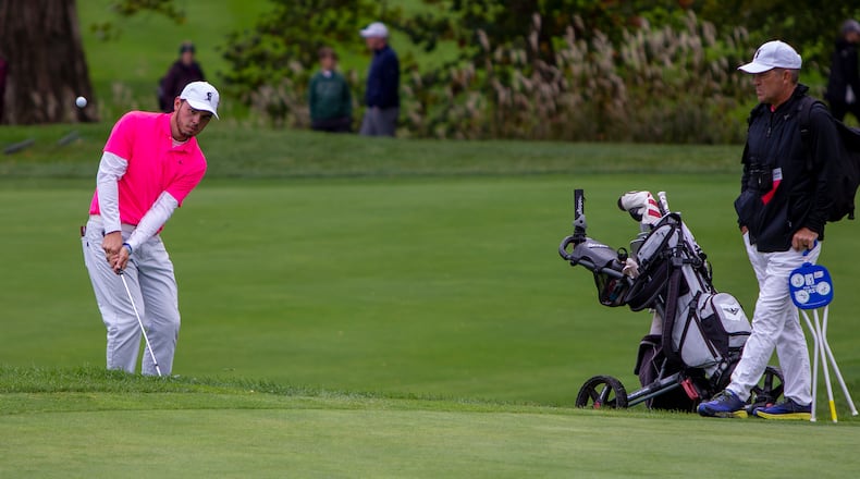 Lakota East senior Joe Wilson IV chips onto the green as coach Jeff Combs looks during final round of the Division I boys state golf tournament in 2021. JEFF GILBERT/CONTRIBUTED