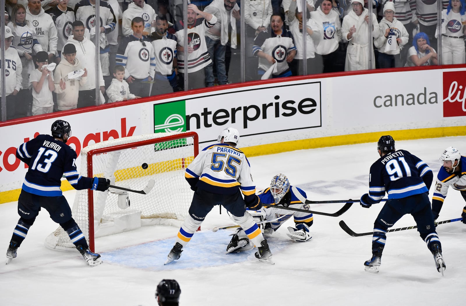 Winnipeg Jets' Cole Perfetti (91) scores against St. Louis Blues goaltender Jordan Binnington (50) during the third period of Game 7 in an NHL hockey first-round playoff series in Winnipeg, Manitoba, Sunday, May 4, 2025. (Fred Greenslade/The Canadian Press via AP)