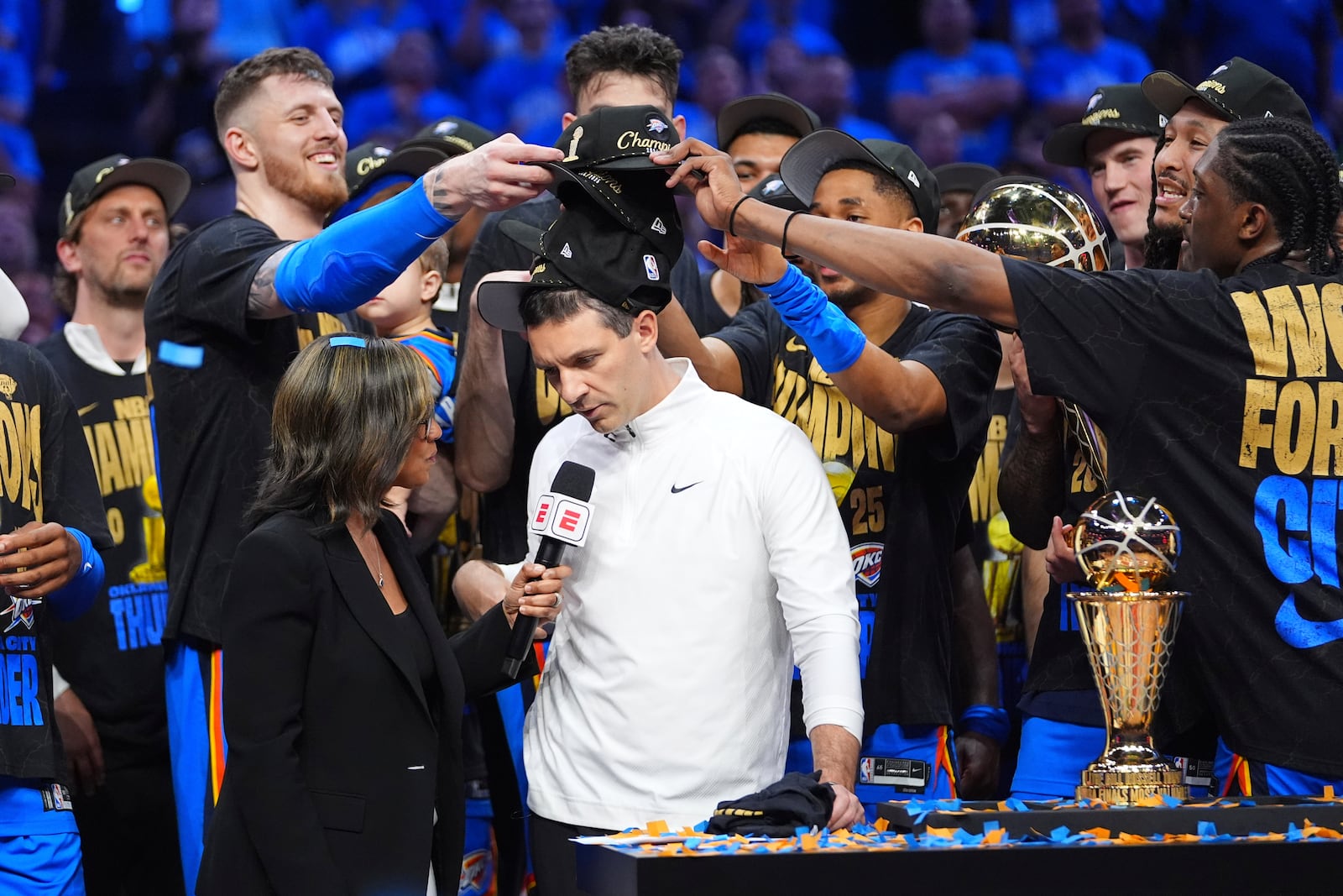 Oklahoma City Thunder players put hats on the head of head coach Mark Daigneault, center, as they celebrate winning the NBA basketball championship with a Game 7 victory against the Indiana Pacers Sunday, June 22, 2025, in Oklahoma City. (AP Photo/Julio Cortez)