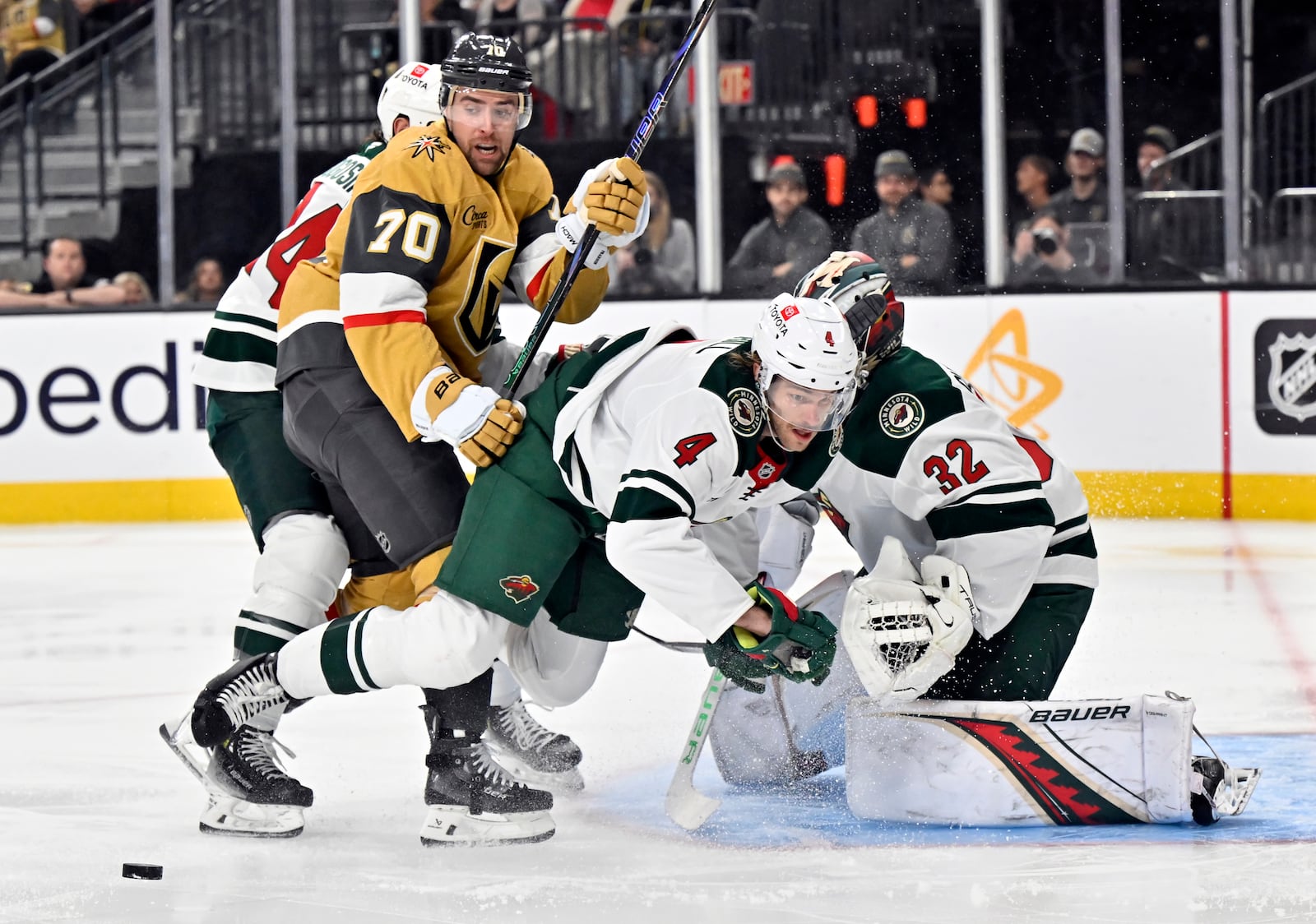Minnesota Wild defenseman Jon Merrill (4) and goaltender Filip Gustavsson (32) defend the net against Vegas Golden Knights left wing Tanner Pearson (70) during the second period of Game 5 of a first-round NHL hockey playoff series Tuesday, April 29, 2025, in Las Vegas. (AP Photo/David Becker)