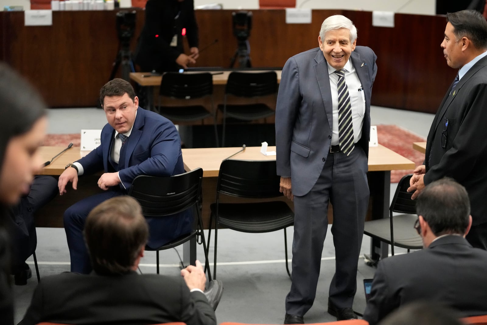 Brazil's former President Jair Bolsonaro, back to camera at left, talks with General Augusto Heleno, the former minister of the Institutional Security Cabinet, standing, before their Supreme Court trial, along with others, facing charges of an alleged coup plot to keep Bolsonaro in office after his 2022 election defeat, in Brasilia, Brazil, Tuesday, June 10, 2025. (AP Photo/Eraldo Peres)