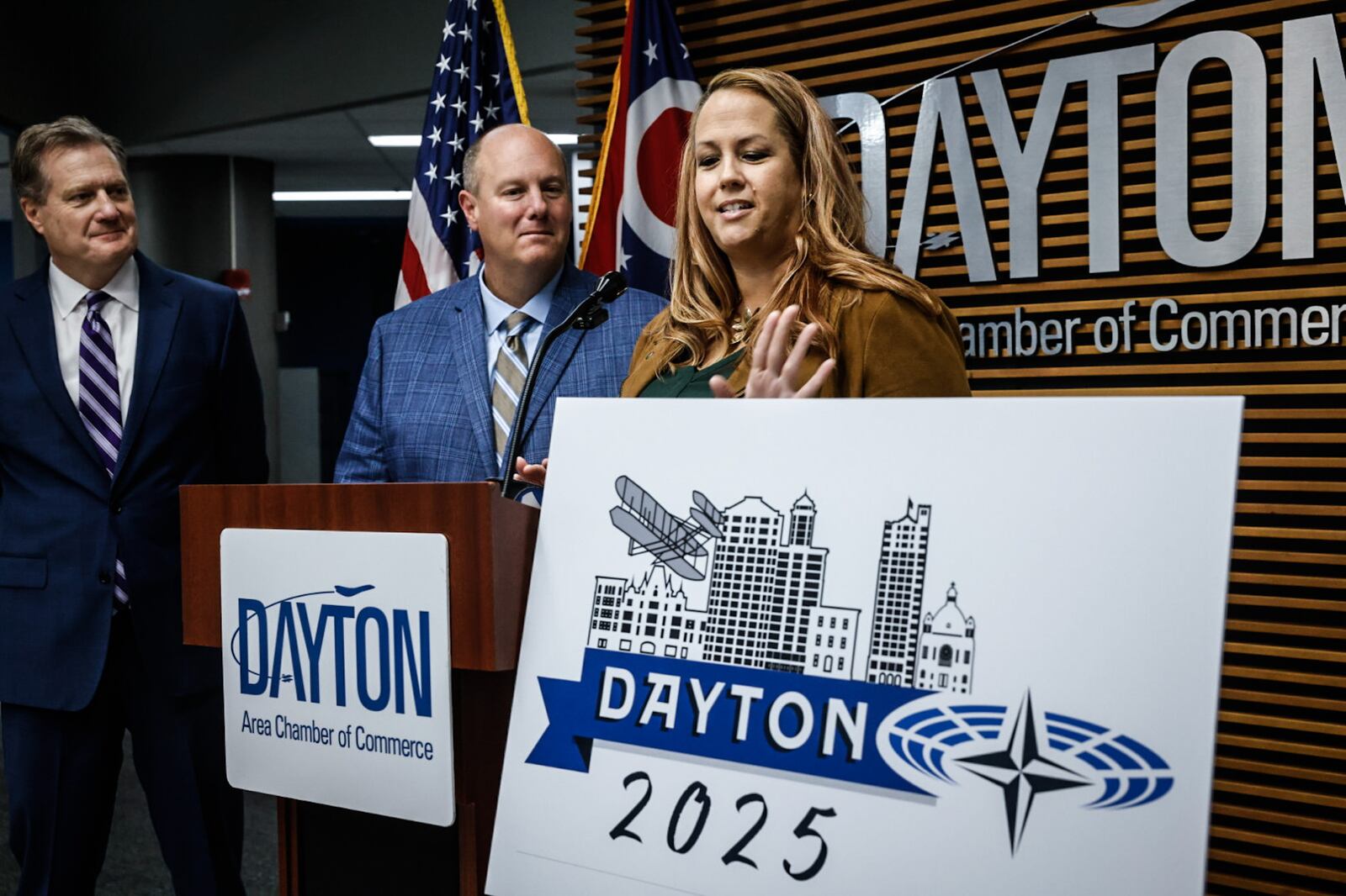 From Left, Ohio Congressman Mike Turner, President and CEO of the Dayton Area Chamber of Commerce Chris Kershner and Founder & President of DezignHive Kim Swigart reveal of the NATO Assembly logo Thursday October 31 at the chamber office. Swigart, who is from Springboro, won the logo contest. JIM NOELKER/STAFF