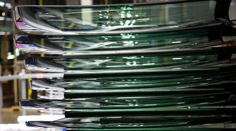 Workers at Fuyao Glass America finish an automobile windshield in the Moraine plant. TY GREENLEES / STAFF