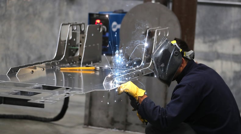 A worker welds a custom built aluminum body frame for a Venice roadster model vehicle at the Vanderhall Motor Works manufacturing facility in Provo, Utah. GEORGE FREY / BLOOMBERG