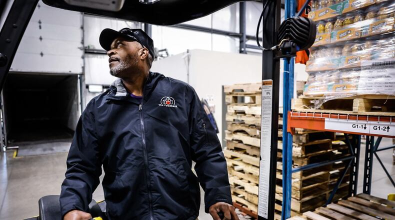 Foodbank Inc. employee El Logan moves crates of food around the warehouse on Armor Place in Dayton Thursday November 7, 2024. JIM NOELKER/STAFF