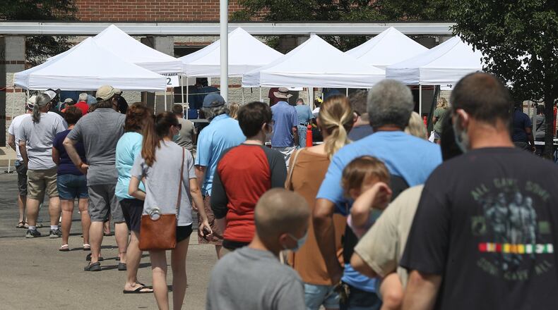 People wait in line at the Clark County Combined Health District’s free COVID-19 testing clinic at Perrin Woods Elementary School in Springfield Wednesday. BILL LACKEY/STAFF