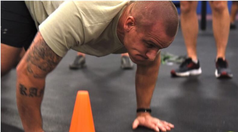 A tactical air control party Airman grimaces while running through a new fitness test designed to measure how well TACP airmen are able to perform the tasks they might be called upon to perform in combat. The Air Force is further delaying fitness assessments due to the coronavirus. (Staff Sgt. Joe Yanik/Air Force)