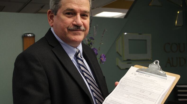 Montgomery County Auditor Karl Keith holds up the forms residents must fill out to apply for the homestead exemption program. CORNELIUS FROLIK / STAFF
