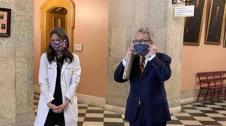 Ohio Gov. Mike DeWine and Ohio Health Department Director Dr. Amy Acton show off their protective masks at the statehouse on Monday. Photo by Laura A Bischoff..Columbus bureau