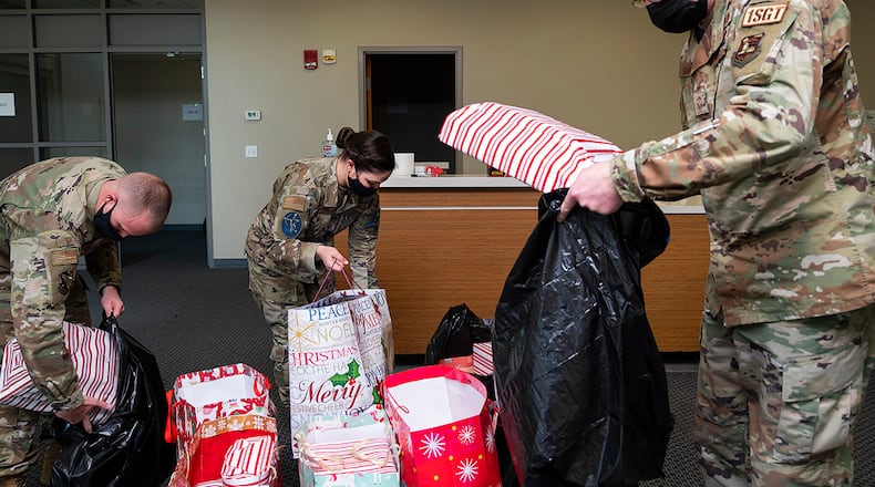 Tech. Sgt. Austin Edington (left), U.S. Air Force School of Aerospace Medicine; Master Sgt. Karla McCool, 73rd Intelligence, Surveillance and Reconnaissance Squadron; and Senior Master Sgt. Timothy Sigafoos, National Air and Space Intelligence Center first sergeant, sort donated gifts for the First Sergeants Council’s annual Adopt-A-Family Program on Dec. 3 at Wright-Patterson Air Force Base. The wrapped presents were placed in bags marked with recipient code names for distribution. U.S. AIR FORCE PHOTO/R.J. ORIEZ