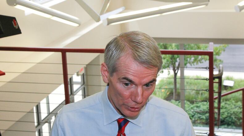 Engineering firm Woolpert has added four drone pilots to its workforce. In this 2013 photo, Sen. Rob Portman visited Woolpert’s Beavercreek headquarters, with a UAV hanging behind him. CHRIS STEWART / STAFF