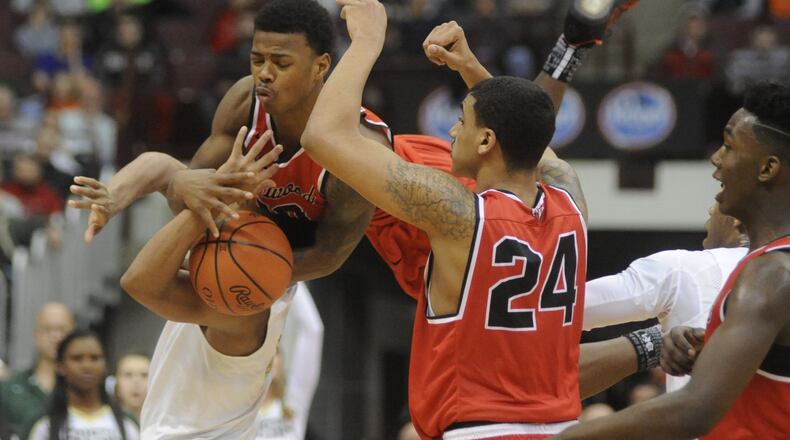 Trotwood’s Caleb Johnson (top) goes airborne in joining teammates Torrey Patton (24) and Myles Belyeu in making a defensive stop. Akron St. Vincent-St. Mary defeated Trotwood-Madison 62-60 in a boys high school basketball D-II state semifinal at OSU’s Schottenstein Center in Columbus on Thursday, March 23, 2017. MARC PENDLETON / STAFF