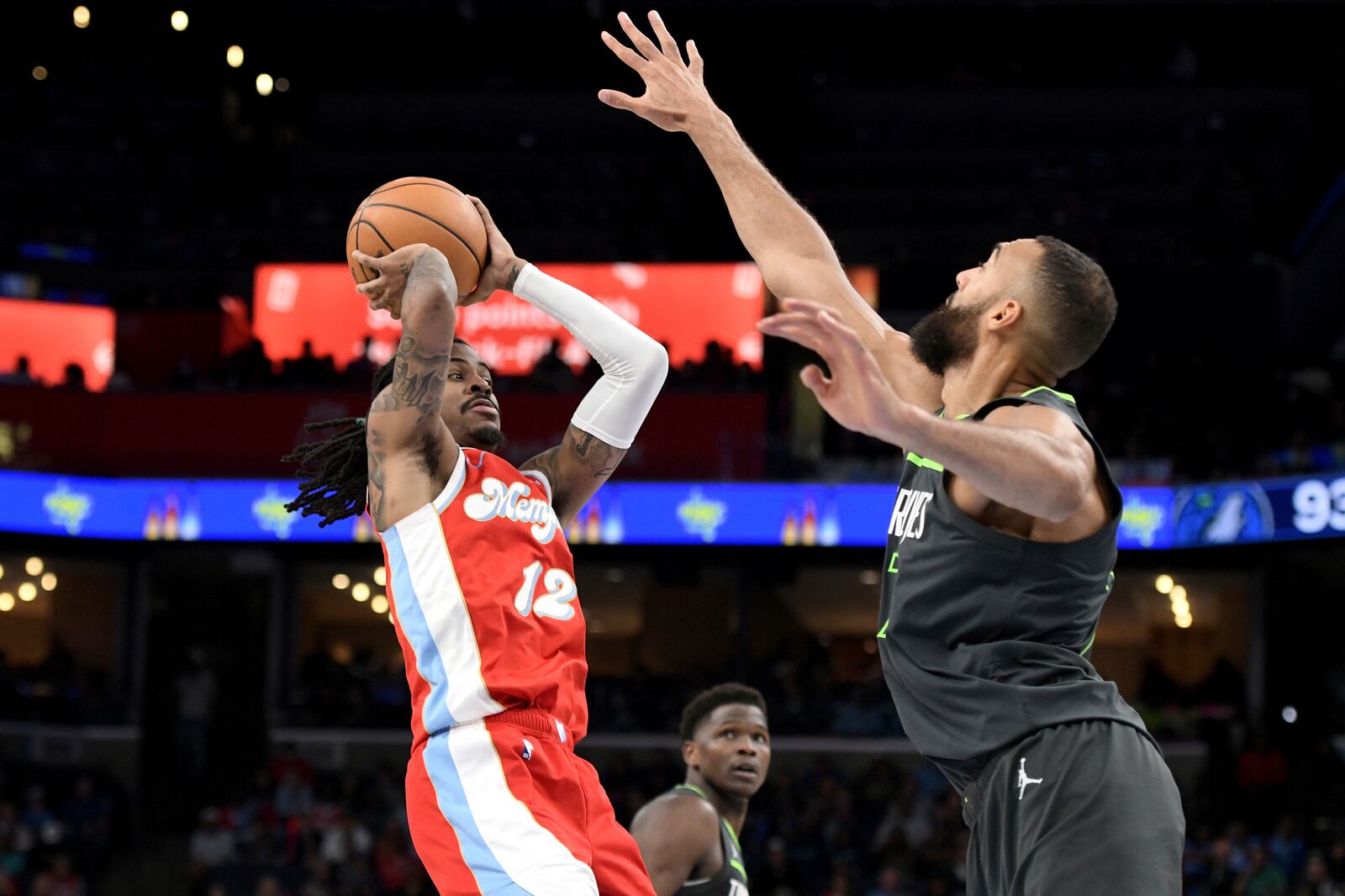 Memphis Grizzlies guard Ja Morant (12) handles the ball against Minnesota Timberwolves center Rudy Gobert, right, in the second half of an NBA basketball game Thursday, April 10, 2025, in Memphis, Tenn. (AP Photo/Brandon Dill)