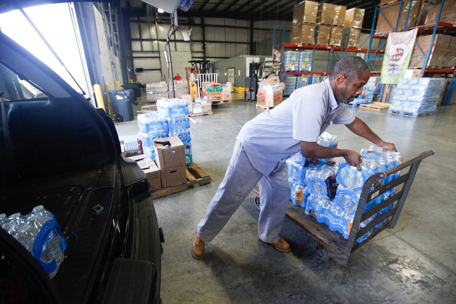 Marvin Adcock of Dayton was among those dropping off cases of bottled water Wednesday at The Foodbank to aid Texas victims of Harvey. CHRIS STEWART / STAFF