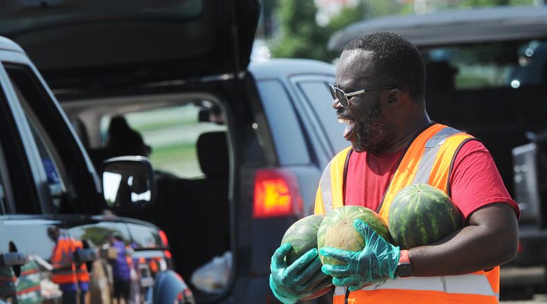 Veto Mason helps with The Foodbank Inc. drive-thru food distribution at the old Salem Mall in Trotwood Thursday Sept. 15, 2022. MARSHALL GORBY\STAFF