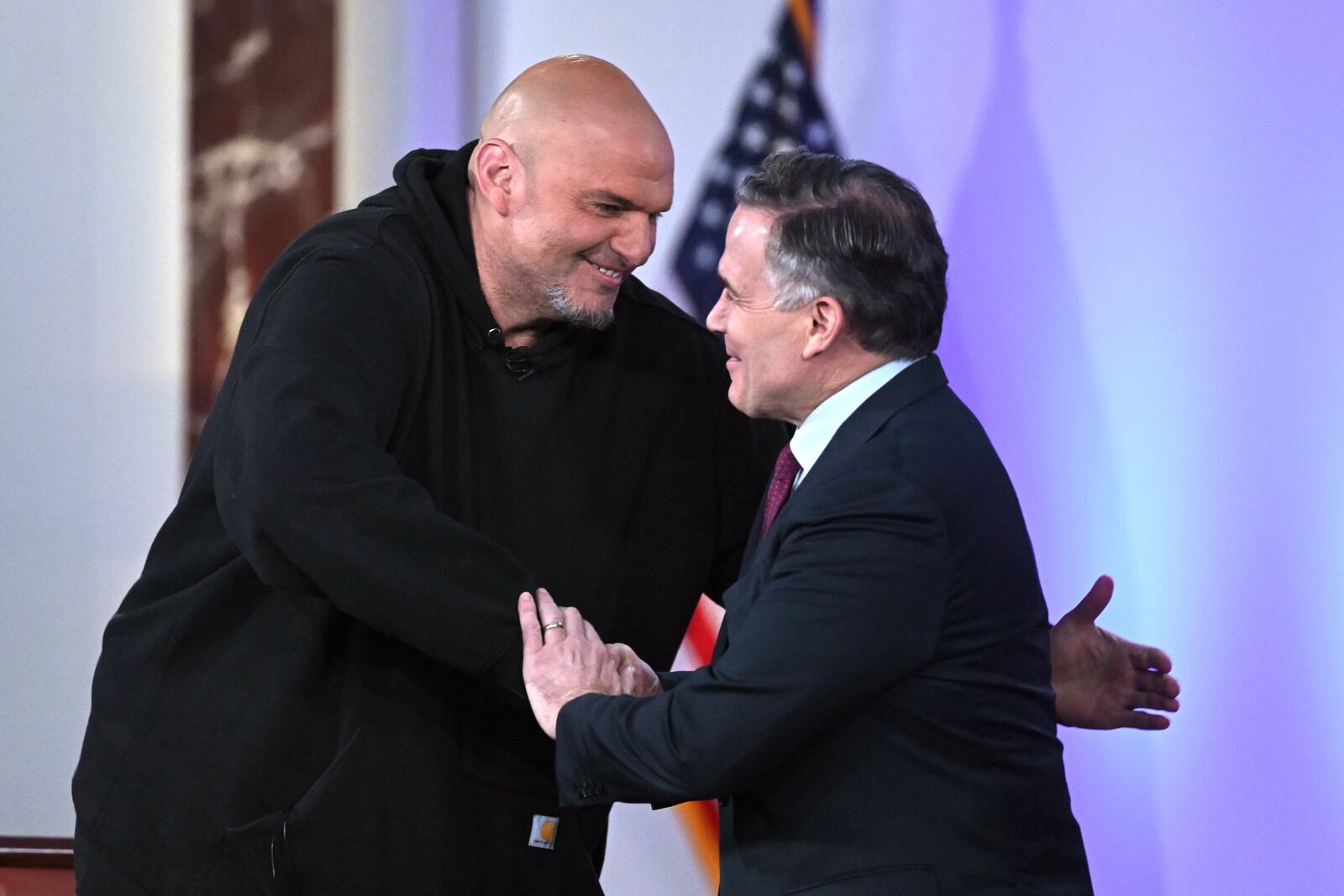 Sen. John Fetterman, D-Penn., left, and Sen. Dave McCormick, R-Penn., right, greet before participating in a debate moderated by Fox News anchor Shannon Bream, not shown, Monday, June 2, 2025, at the Edward M. Kennedy Institute for the United States Senate, Monday, June 2, 2025, in Boston. (AP Photo/Steven Senne)