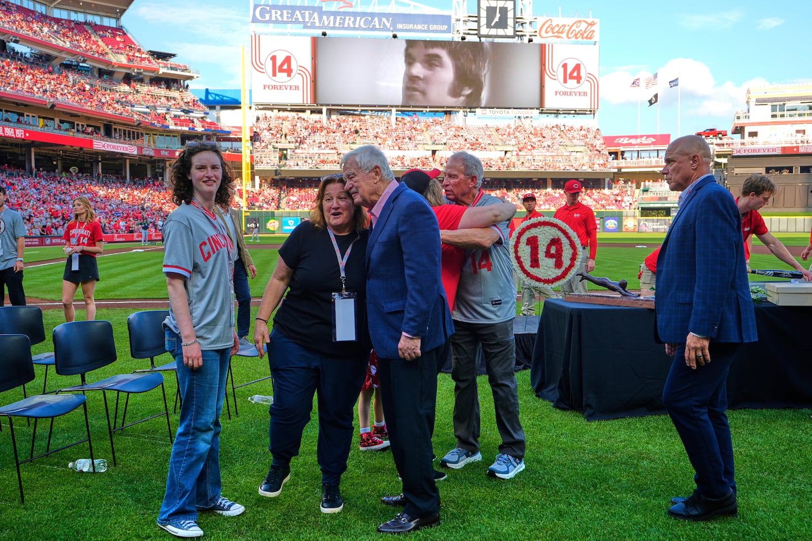 Cincinnati Reds owner Bob Castellini, right hugs Pete Rose's daughter Fawn Rose as they meet on the field for Pete Rose Night events before a baseball game between the Cincinnati Reds and the Chicago White Sox, Wednesday, May 14, 2025, in Cincinnati. (AP Photo/Carolyn Kaster)