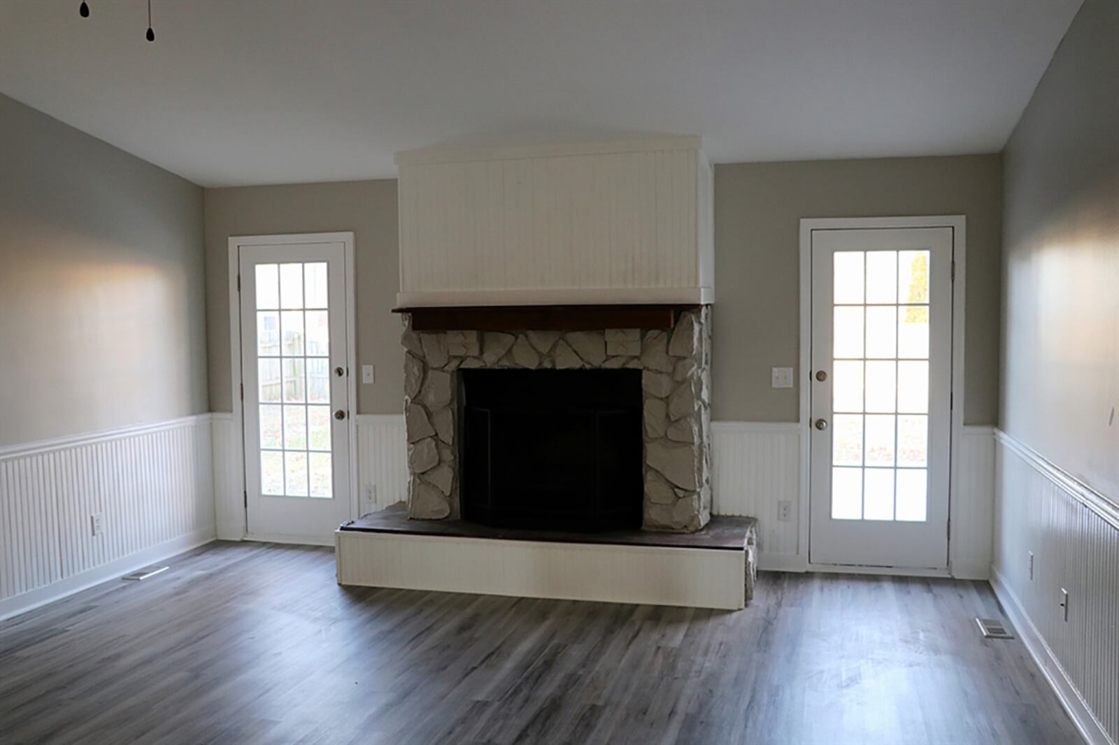 At the entrance of the house is the combined family room and dining room. A wood-burning fireplace has received a façade update with stone surround and a raised hearth and wood-beam mantel. CONTRIBUTED PHOTO BY KATHY TYLER