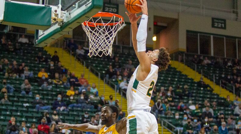 Wright State's Tanner Holden goes in for a dunk over Tafari Simms off a Milwaukee turnover early in Thursday night's game at the Nutter Center. Jeff Gilbert/CONTRIBUTED