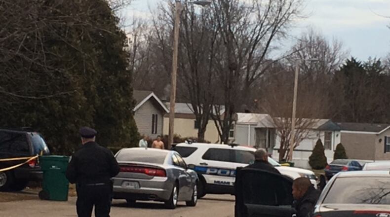 Miami Township police and bystanders in the area near the deadly officer-involved shooting in Oakwood Village this morning. NICK BLIZZARD/STAFF PHOTO