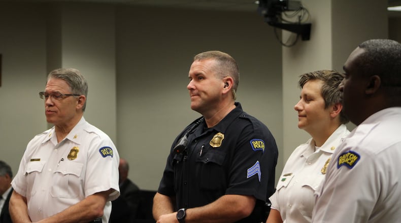 Dayton police Sgt. William Gross, flanked by the police chief and command staff, was honored this week for preventing a man from jumping off a bridge. CORNELIUS FROLIK / STAFF