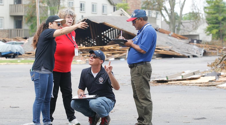 From left, Malyssa Suarez, with the Federal Emergency Management Agency (FEMA), Brigitte Bouska, with the Ohio Emergency Management Agency, Steve Cooper, of FEMA, and Ahmed Hossain, of the Small Business Administration, conduct a joint preliminary assessment of tornado damage Wednesday, June 5, at the Woodland Hills Apartments in Trotwood. CHRIS STEWART / STAFF