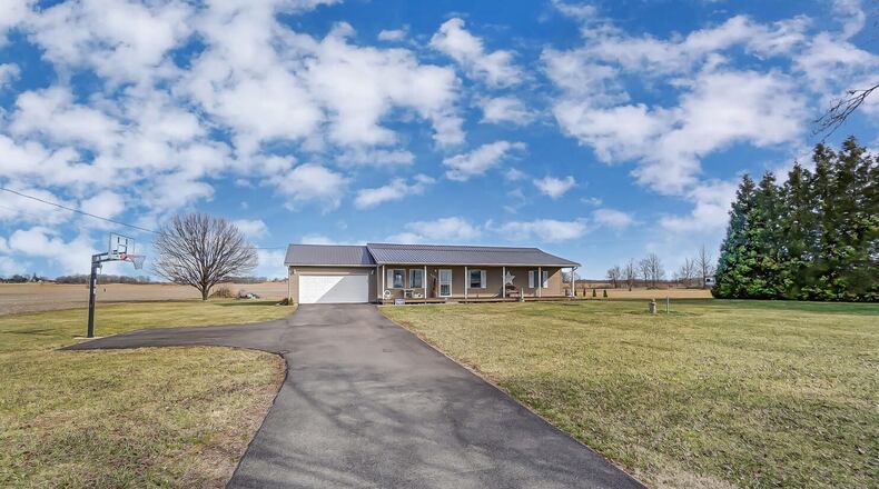 The front of the custom-built ranch home has a long newly paved driveway, basketball hoop, full wood front porch and attached two-car garage. Contributed photos