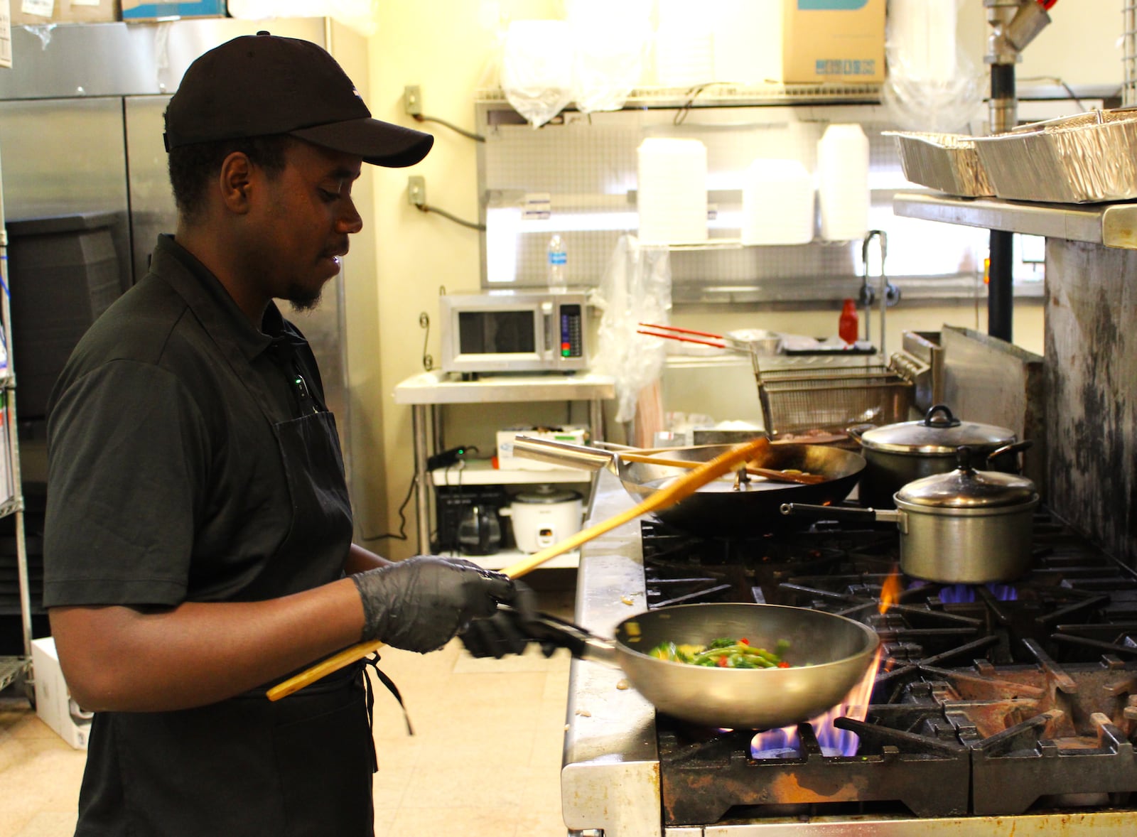 Angelo Ihirwe prepares a vegatable medley in the kitchen he operates with his mother, Solange Asingabona. STAFF/SYDNEY DAWES