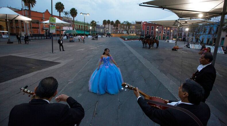 FILE PHOTO: Quinceanera Ximena Ferrusquilla dances as mariachis perform in her honor to mark her 15th birthday in the popular Garibaldi square, now empty of visitors, in Mexico City, Friday, April 3, 2020. Girls in the U.S. are having similar celebrations during social distancing.
