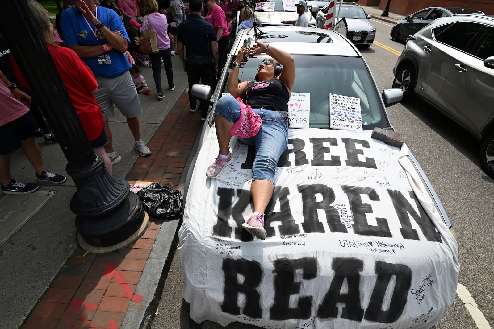 Dina Warchal, of Waltham, MA, a Karen Read supporter, listens to closing arguments of Read's trial from her car parked at the edge of the protest buffer zone around Norfolk Superior Court, Friday, June 13, 2025, in Dedham, Mass. (AP Photo/Josh Reynolds)