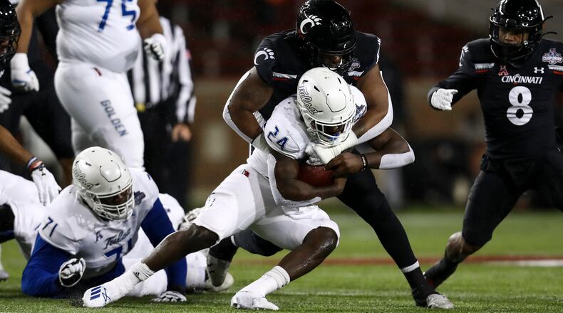 Cincinnati defensive end Malik Vann (42) tackles Tulsa running back Corey Taylor II (24) as he carries the ball during the first half of the American Athletic Conference championship NCAA college football game, Saturday, Dec. 19, 2020, in Cincinnati. (AP Photo/Aaron Doster)