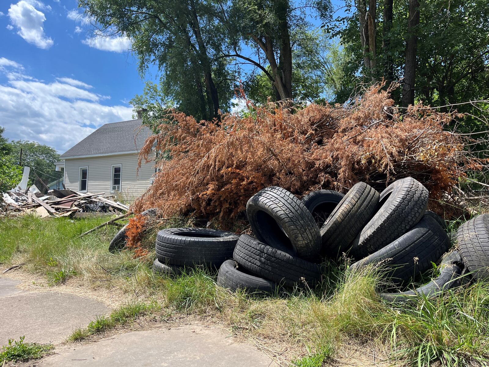 A pile of more than 20 scrap and abandoned tires on McClain Street in East Dayton. The mound of tires is adjacent to a property that is filled with debris. CORNELIUS FROLIK / STAFF