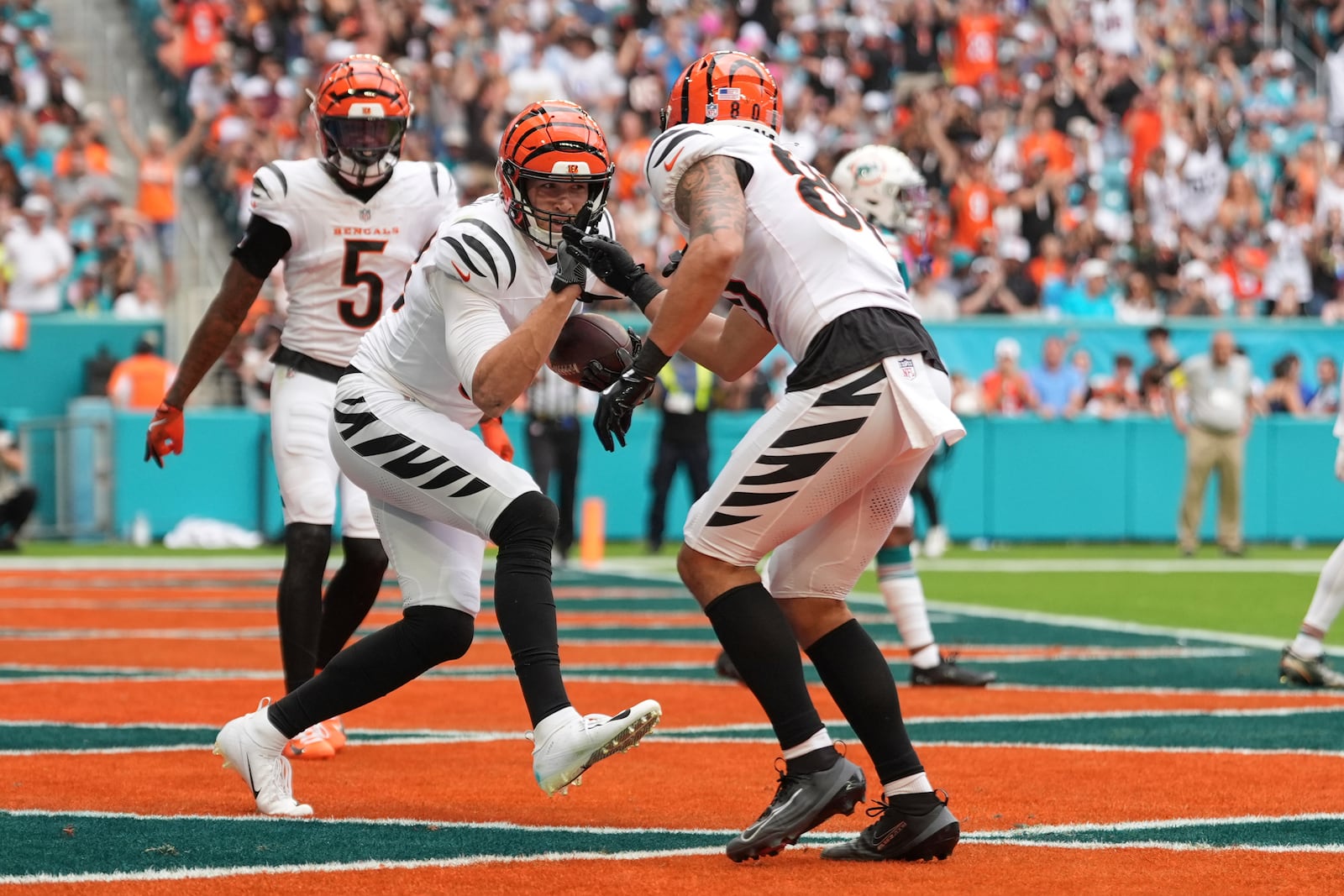 Cincinnati Bengals tight end Mike Gesicki, front left, celebrates after his touchdown with wide receiver Andrei Iosivas (80) during the second half of an NFL football game against the Miami Dolphins, Sunday, Dec. 21, 2025, in Miami Gardens, Fla. (AP Photo/Rebecca Blackwell)