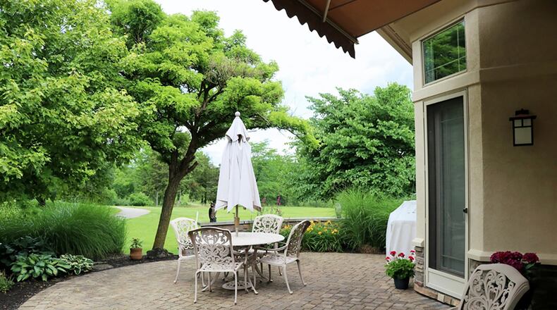 Glass doors off the breakfast room and the main bedroom open to a circular, paver-brick patio, part of which is covered by a retractable awning.
