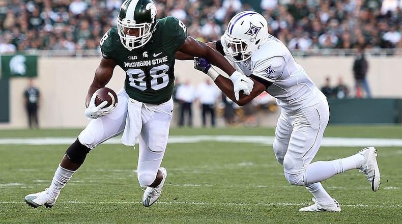 EAST LANSING, MI - SEPTEMBER 02: Monty Madaris #88 of the Michigan State Spartans avoids a tackle by Thomas Brown #6 of the Furman Paladins during the first half of a game at Spartan Stadium on September 2, 2016 in East Lansing, Michigan. (Photo by Stacy Revere/Getty Images)