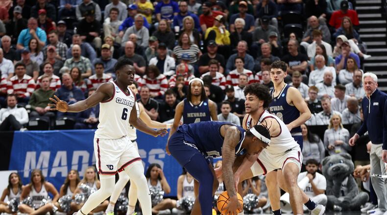 Dayton's Enoch Cheeks and Nate Santos force a turnover against Nevada in the first round of the NCAA tournament on Thursday, March 21, 2024, at the Delta Center in Salt Lake City, Utah. David Jablonski/Staff