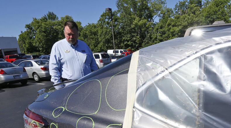 Voss Collision Center repair manager Mike Moore with a tornado damaged Toyota where company officials say they have seen a twenty percent increase in business from tornado related repairs. TY GREENLEES / STAFF