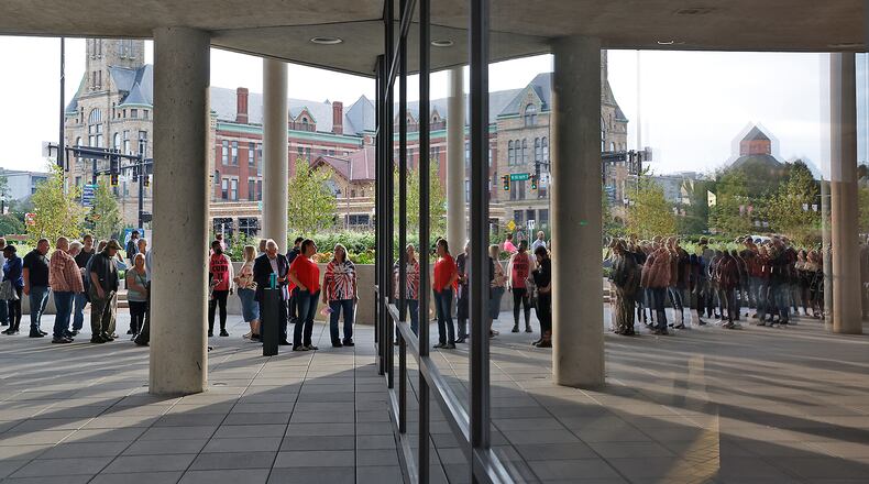 People are reflected in the windows of the Springfield City Hall Forum as they wait to be let in for the City Commission meeting Tuesday, Sept. 25, 2024. BILL LACKEY/STAFF