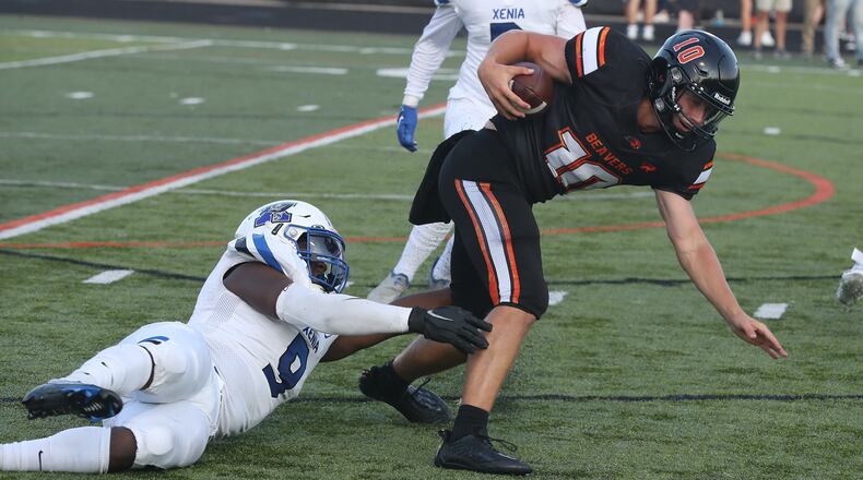 Beavercreek quarterback Spencer Johnson tries to avoid a tackle by Xenia's Jamel Smith during Friday's season opener. BILL LACKEY/STAFF