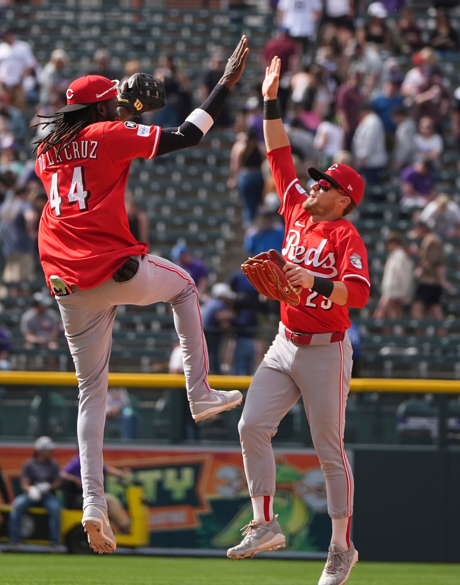 Cincinnati Reds shortstop Elly De La Cruz, left, celebrates with center fielder TJ Friedl, right, after defeating the Colorado Rockies in a baseball game Saturday, April 26, 2025, in Denver. (AP Photo/David Zalubowski)