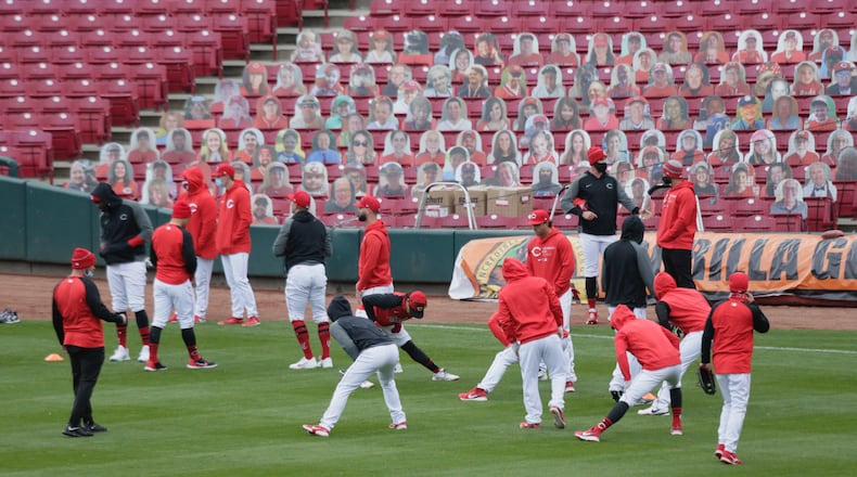 The Reds warm up before batting practice on Opening Day on Thursday, April 1, 2021, at Great American Ball Park in Cincinnati. David Jablonski/Staff