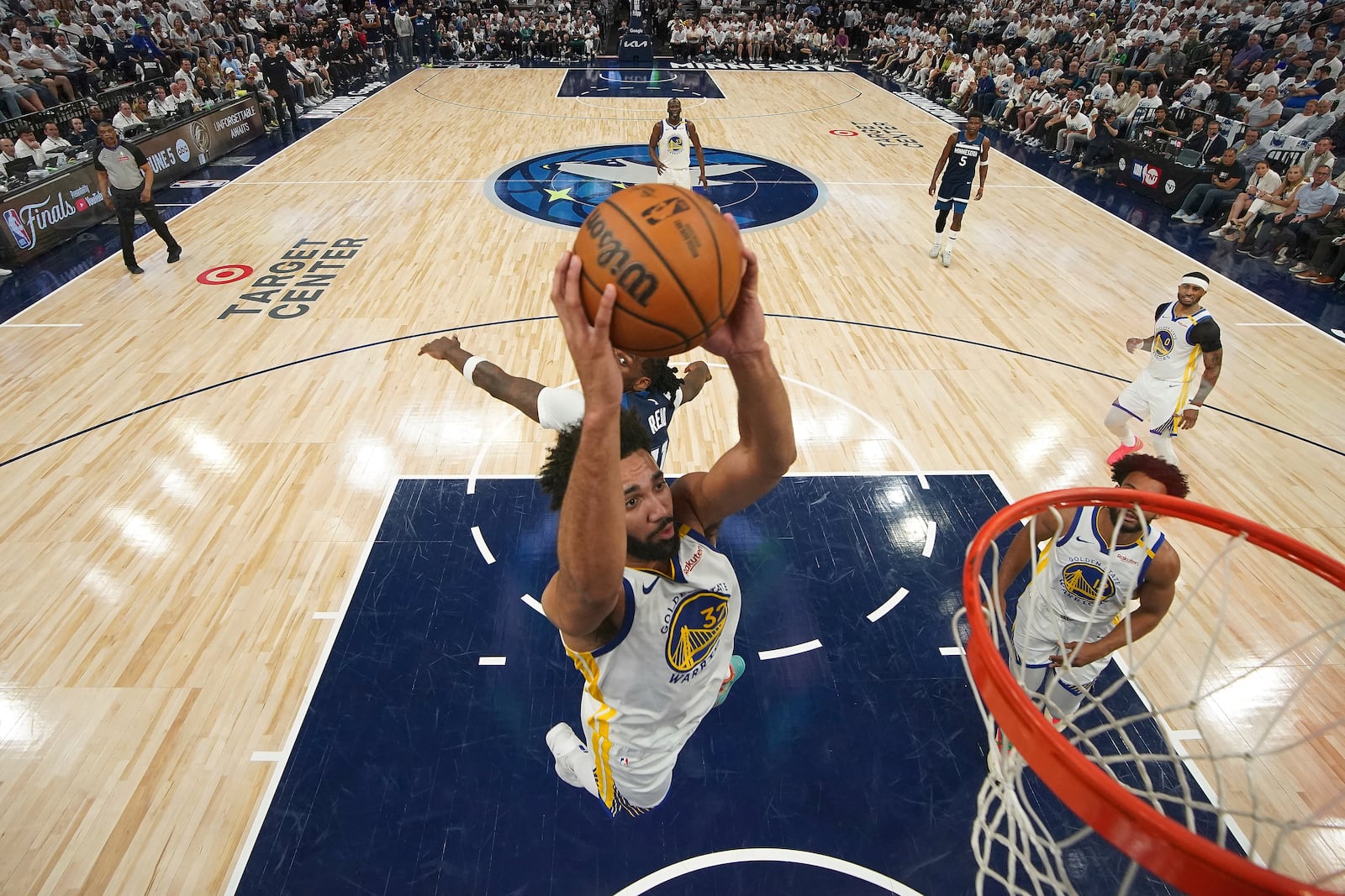 Golden State Warriors forward Trayce Jackson-Davis (32) goes up for a dunk as Minnesota Timberwolves center Naz Reid (11), back, defends during the second half of Game 2 of an NBA basketball second-round playoff series, Thursday, May 8, 2025, in Minneapolis. (AP Photo/Abbie Parr)