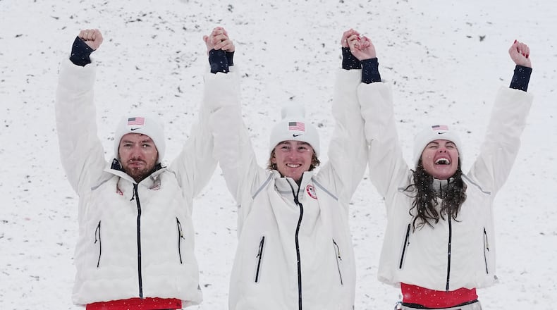 From left, gold medalists United States' Christopher Lillis, Connor Curran and Kaila Kuhn celebrates after the freestyle skiing mixed team aerials final at the 2026 Winter Olympics, in Livigno, Italy, Saturday, Feb. 21, 2026. (AP Photo/Gregory Bull)