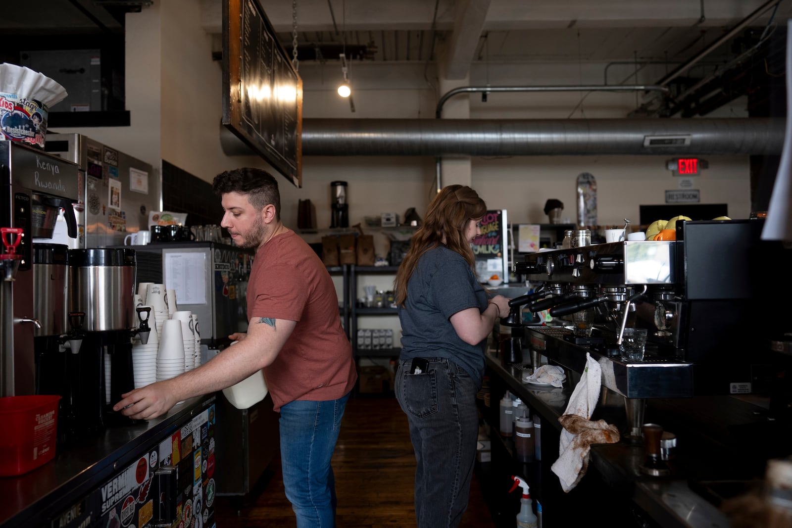 Anderson Miller, left, and Claire Terrelli, right, make coffee at Fuego Coffee Roasters in Rochester, N.Y., Saturday, March 22, 2025. (Max Conway via AP)