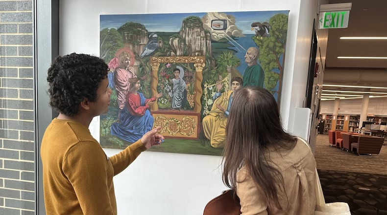 German Sanchez, from Colombia, (left) has a painting called "Con Dolor Comeras de ella Todos los Dias de tu Vida" exhibiting at the downtown Dayton Metro Library. CONTRIBUTED