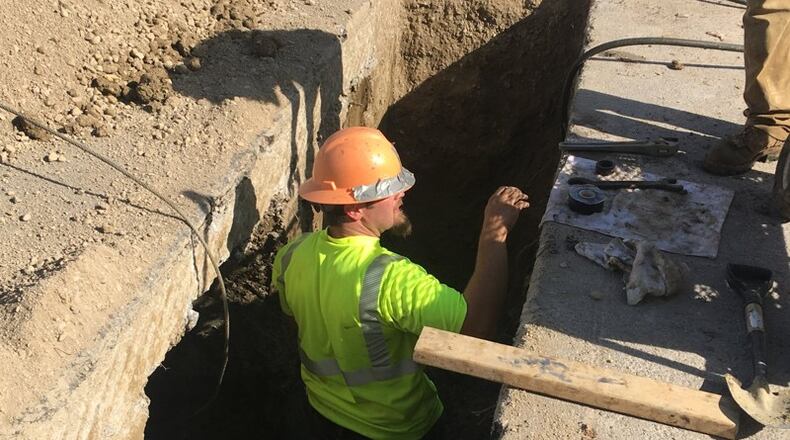 Workers dig up and replace a water main line on Cushing Avenue, off of Shroyer Road in Kettering. KARA DRISCOLL/STAFF