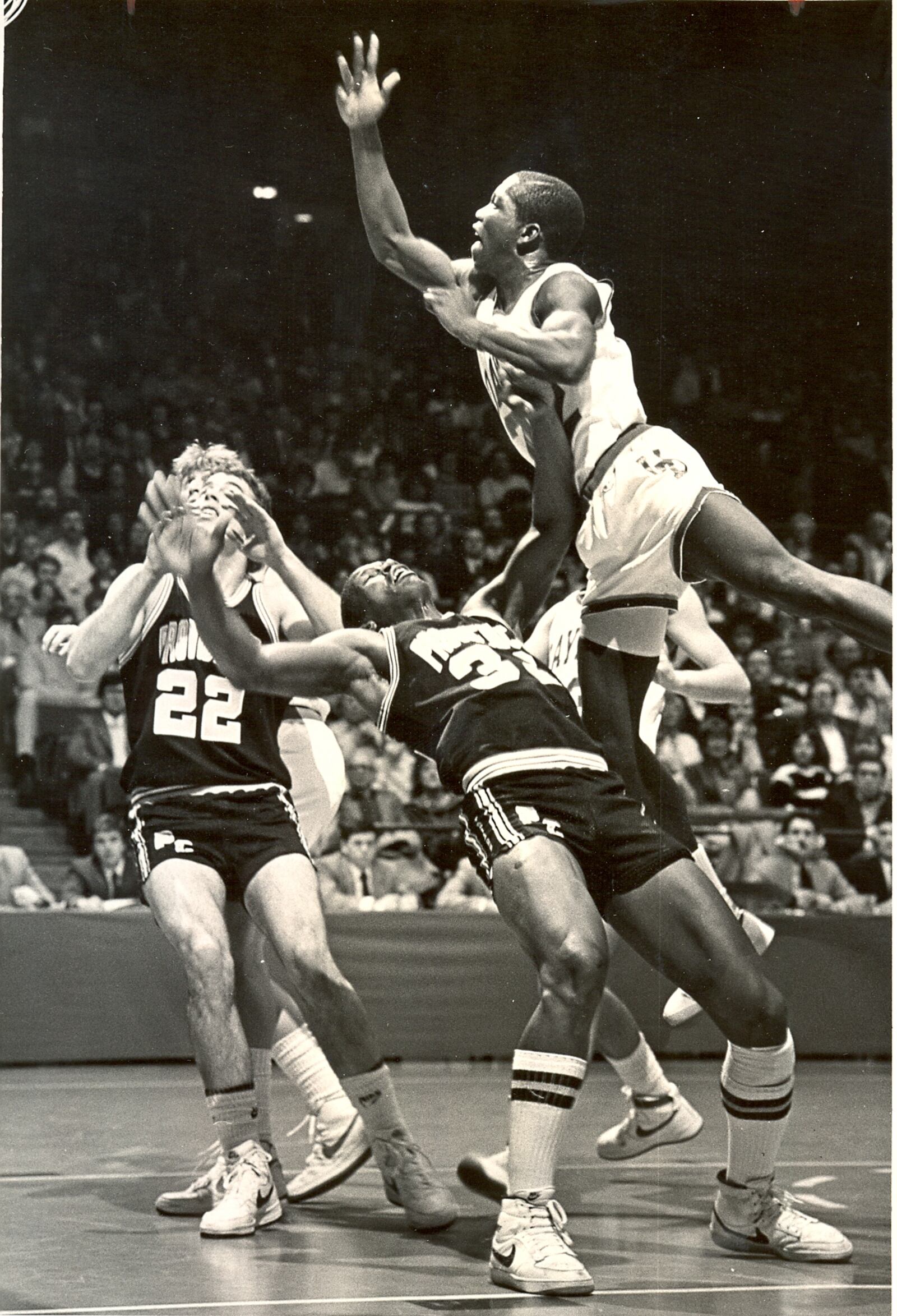 UD's Roosevelt Chapman goes against Providence's Ray Knight (32) and Sean Canty (22) on Jan. 28, 1984. The Flyers came away with a big win, 73-47.